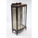 A Walnut small bow-front china display cabinet fitted two plate-glass shelves enclosed by glazed