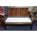 A Chinese-style teak-inlaid two-seater settee with panelled back, hard seats & on shaped legs, 46”
