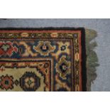 A Persian long rug of fawn ground with row of nine small centre panels within blue-ground borders;