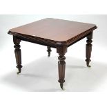 A mahogany extending dining table with turned tapered legs, on ceramic castors, 40” wide x 40”