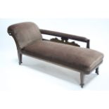 An Edwardian carved oak frame chaise longue upholstered brown velour, & on short square legs with