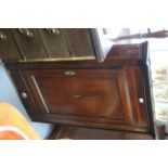 A late 18th century mahogany hanging corner cupboard with inlaid decoration to the panel door,