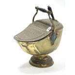 A 19th century brass embossed helmet-shaped coal scuttle with ebonised turned carrying handle, &