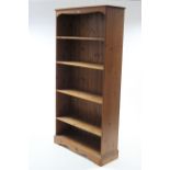 Another pine tall standing open bookcase with four adjustable shelves, & on shaped plinth base,