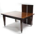 An Edwardian mahogany extending dining table with moulded edge to the rectangular top, with two