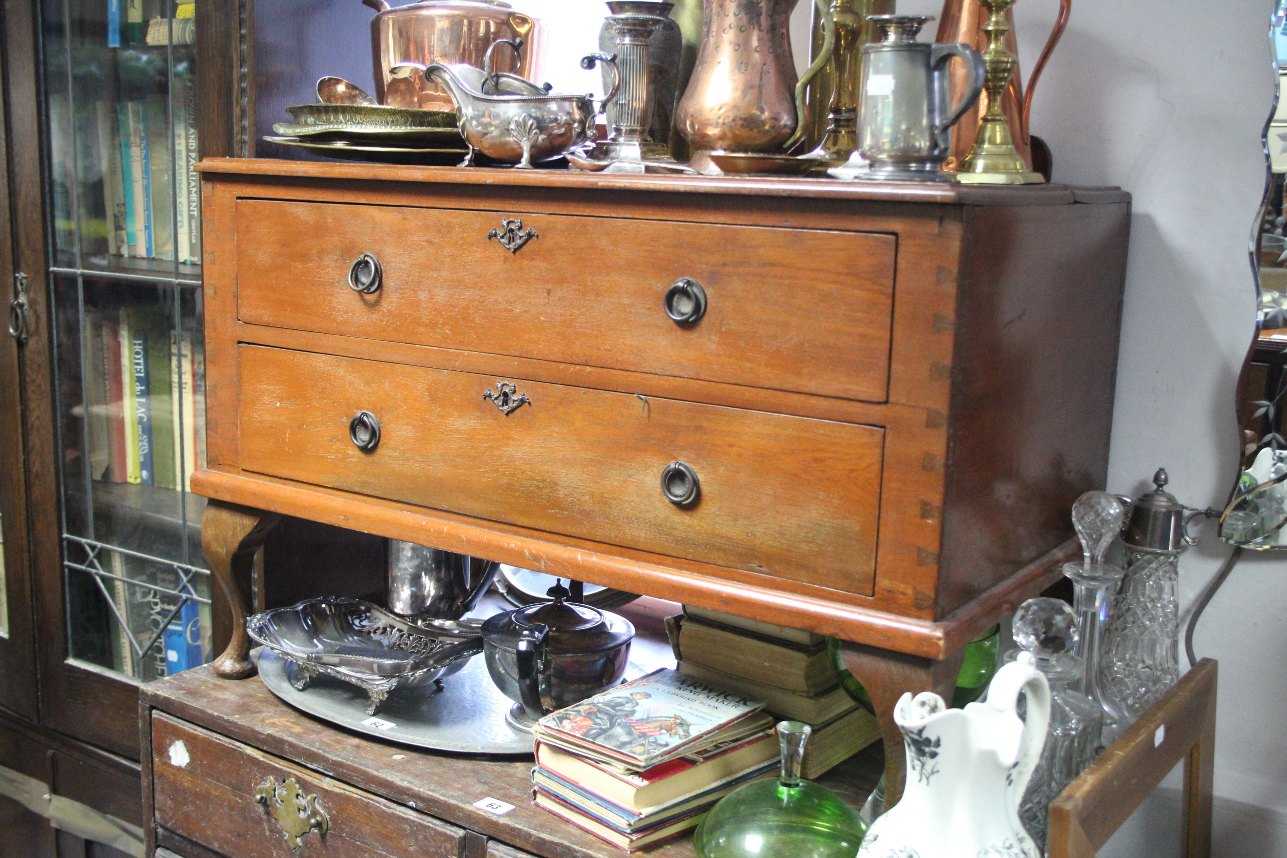 An African hardwood low chest fitted two long drawers with ring handles & on short cabriole legs &