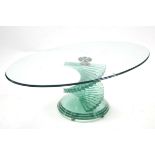 A contemporary coffee table with oval top, spiral centre column & on stepped circular base, 46” x