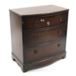 A mahogany small bow-front chest fitted three long graduated drawers with brass ring handles, & on