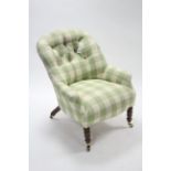 A late Victorian buttoned back armchair upholstered green & white chequered material, & on walnut