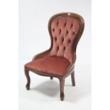 A Victorian-style buttoned-back nursing chair upholstered pink velour, & on short cabriole legs.