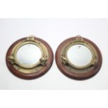 A pair of hardwood frame circular wall mirrors with brass porthole mounts, 14½” diam.