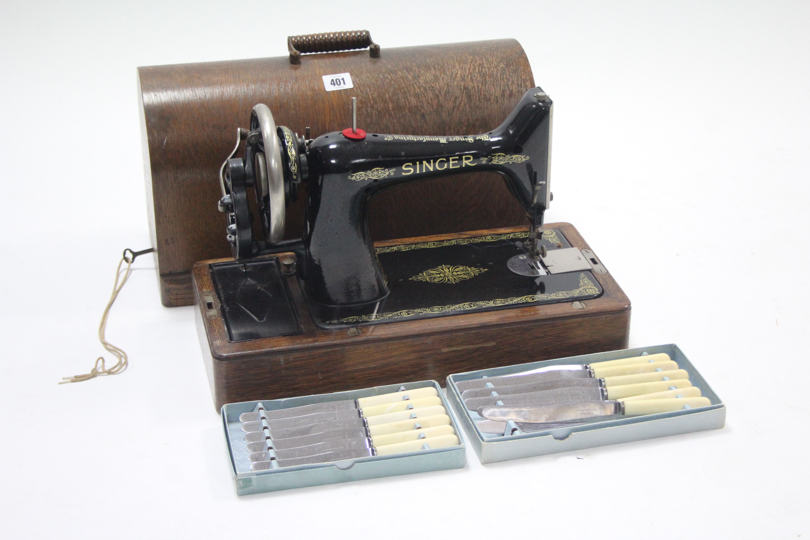 A Singer hand sewing machine with oak case; together with three mincers; & two sets of six knives.