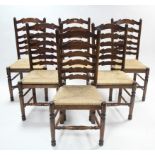 A set of six oak ladder-back dining chairs with woven rush seats & on turned legs with turned &