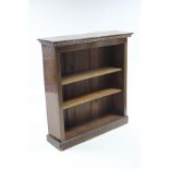 An early 20th century mahogany standing open bookcase with carved frieze, two adjustable
