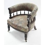 A late Victorian walnut tub-shaped chair with spindle-rail to back, upholstered multi-coloured