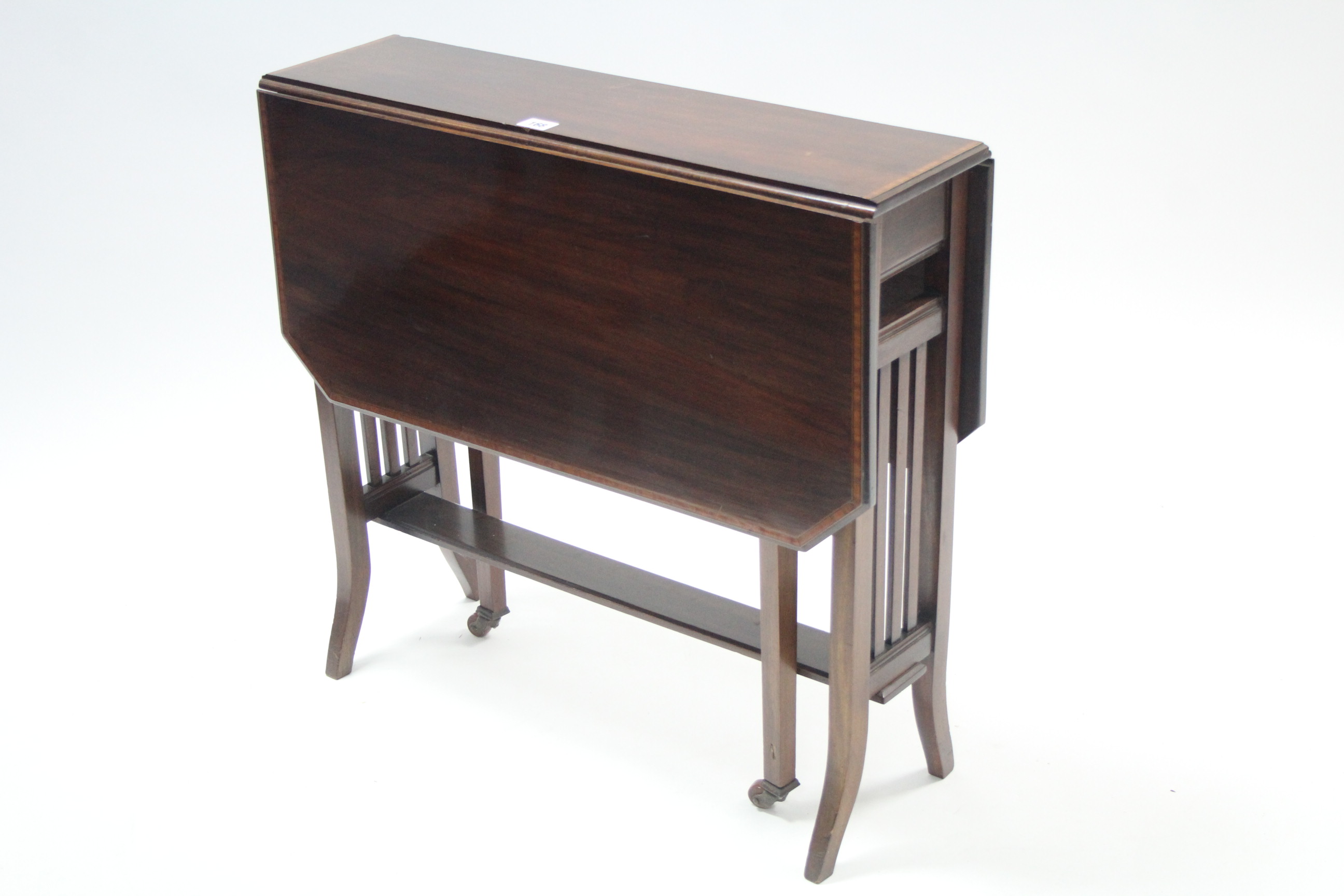 An Edwardian inlaid-mahogany Sutherland table with canted corners to the rectangular top, & on