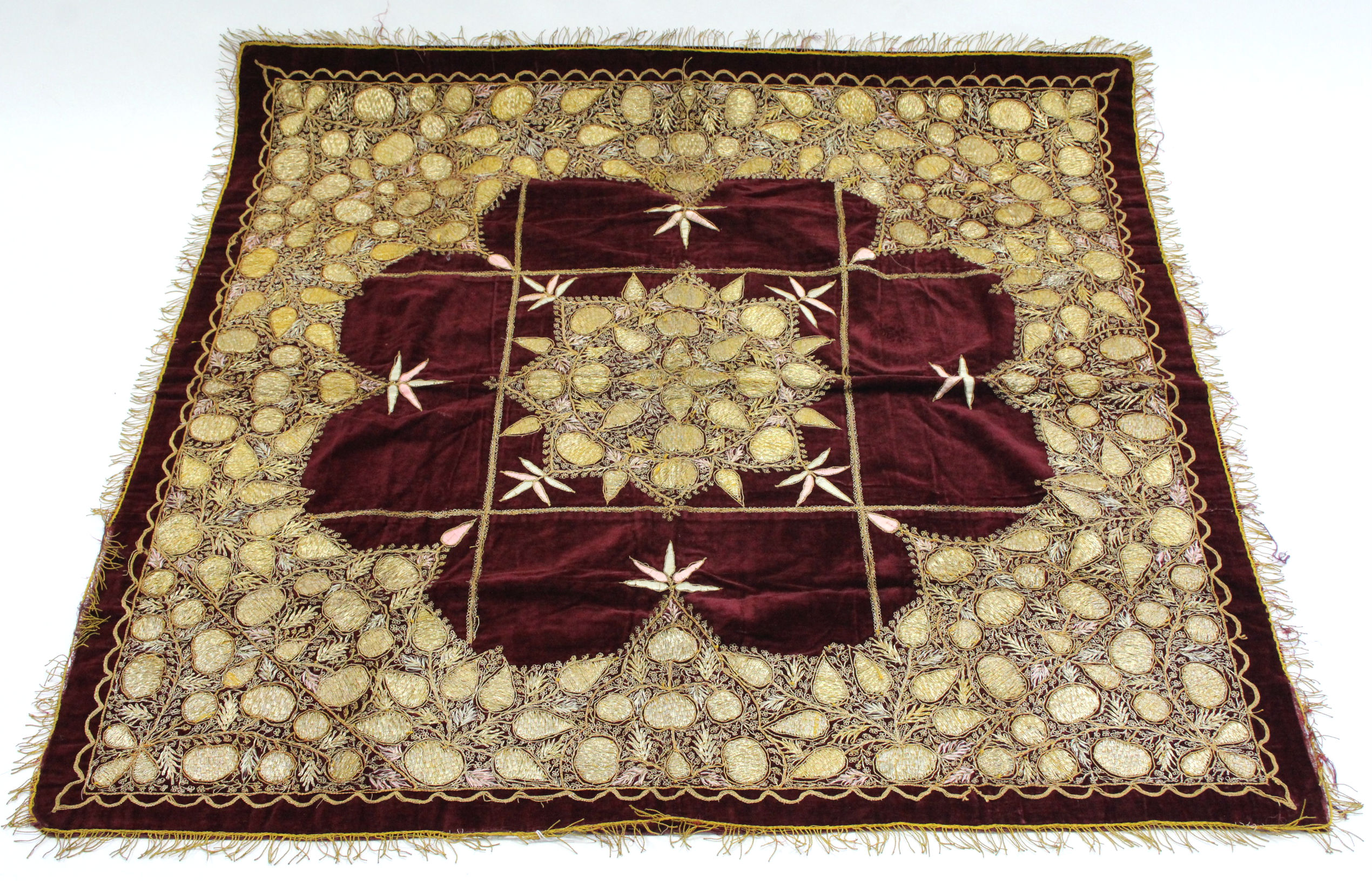 A crimson velour table cover with embroidered gold-thread foliate design, 47" square