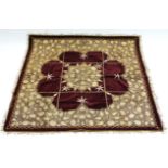 A crimson velour table cover with embroidered gold-thread foliate design, 47" square