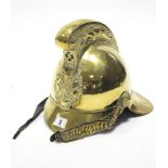 AN ANTIQUE BRASS FIREMAN’S HELMET by RIDER & BELL, with leather chin strap.
