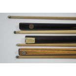 Seven various ash one-piece snooker cues.