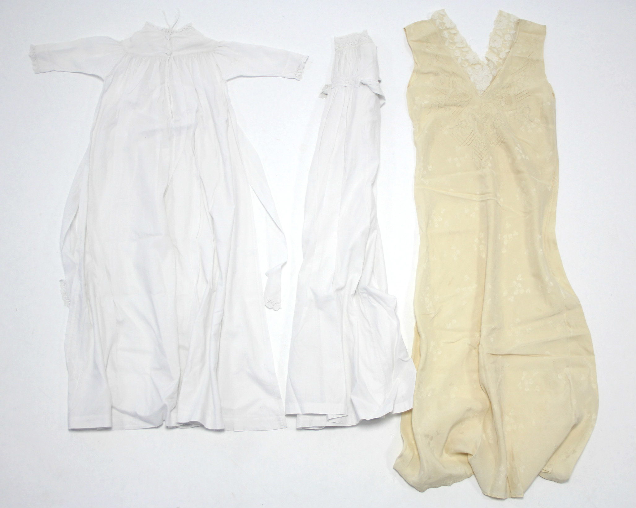 Two Edwardian white cotton children’s nightgowns; & a mid-20th century cream satin ladies’