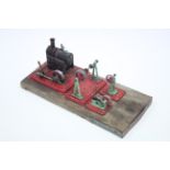 A Mamod stationery steam engine & three ditto accessories mounted on wooden plinth, 20” long.