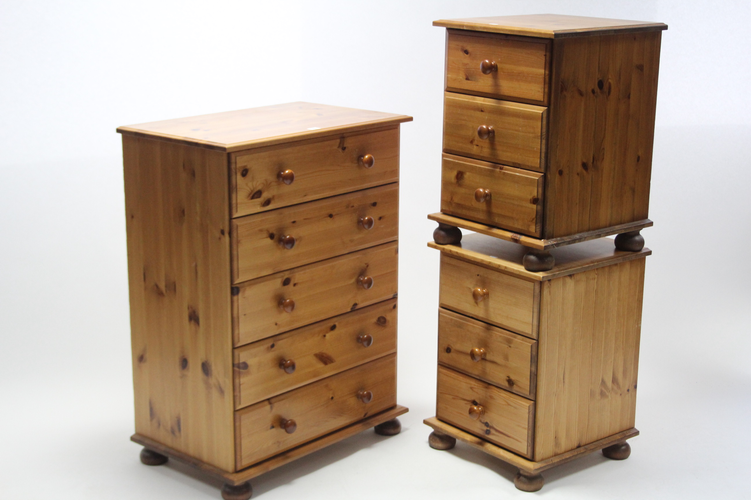 A pine small upright chest fitted five long drawers with turned knob handles, and on bun feet, 27"