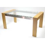 A light oak finish dining table on square legs, with silvered-metal stretchers, & with tempered-