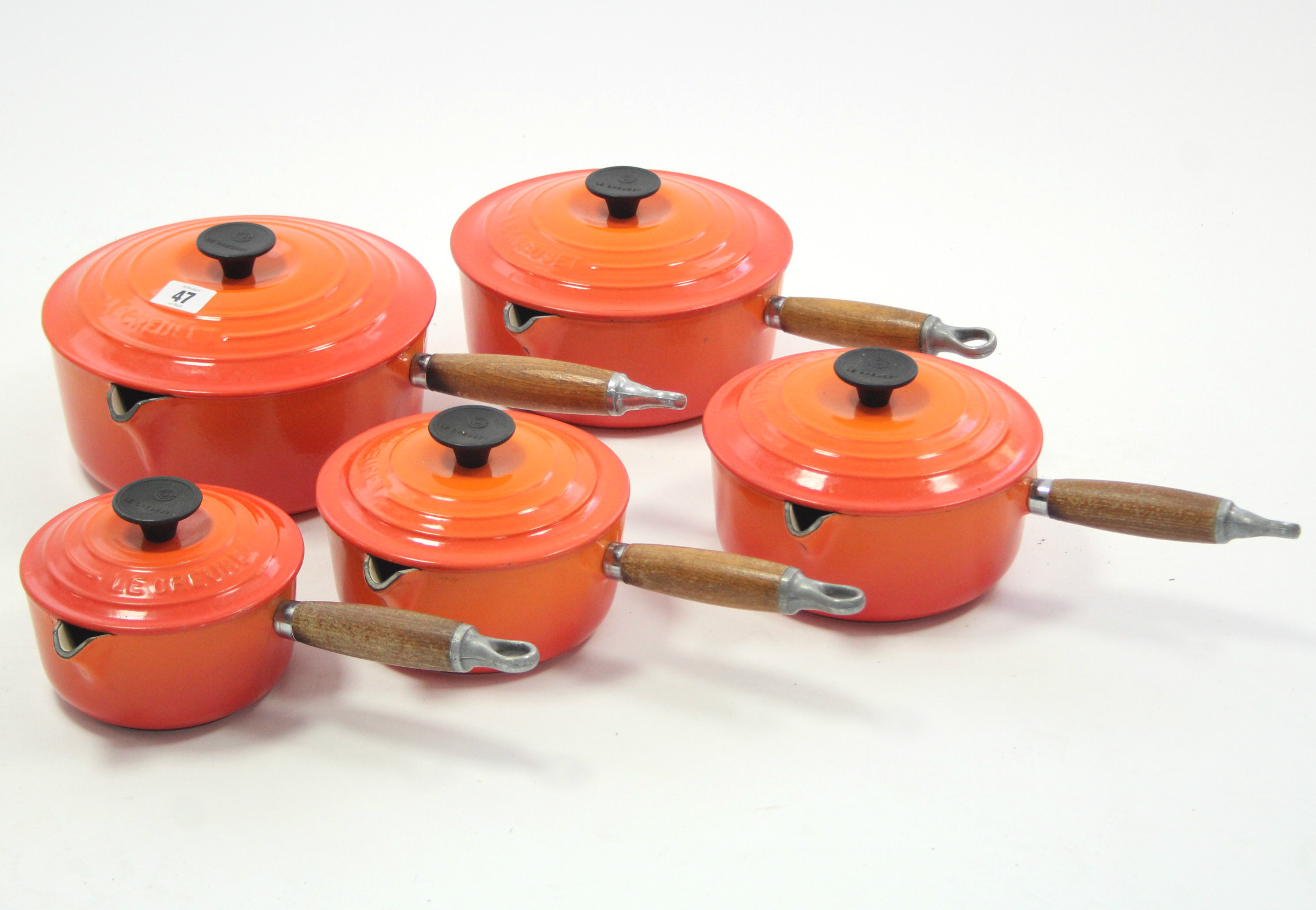 A set of five Le Creuset orange enamelled graduated saucepans, 5¼" - 8¼" diam.