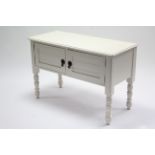 A white painted mahogany washstand enclosed by pair of panel doors, & on short ring-turned legs,