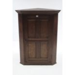 An oak hanging corner cupboard fitted two shelves enclosed by panel door, 30” wide x 39” high.