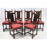 A set of six oak dining chairs (including a pair of carvers) with carved panel backs, padded