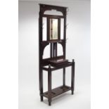 An Edwardian mahogany hallstand inset rectangular bevelled mirror to top above a hinged glove