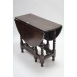 A late 19th/early 20th century oak oval gate-leg table on bobbin-turned legs & turned feet with