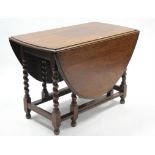 A 1930’s oak oval gate-leg dining table on barley-twist legs & turned feet with plain stretchers,