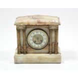 A Victorian mantel clock with two-part dial, striking movement, and in cream onyx architectural
