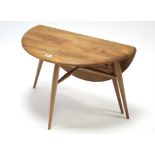 An Ercol light elm circular single drop-leaf occasional table on round tapered legs with spindle