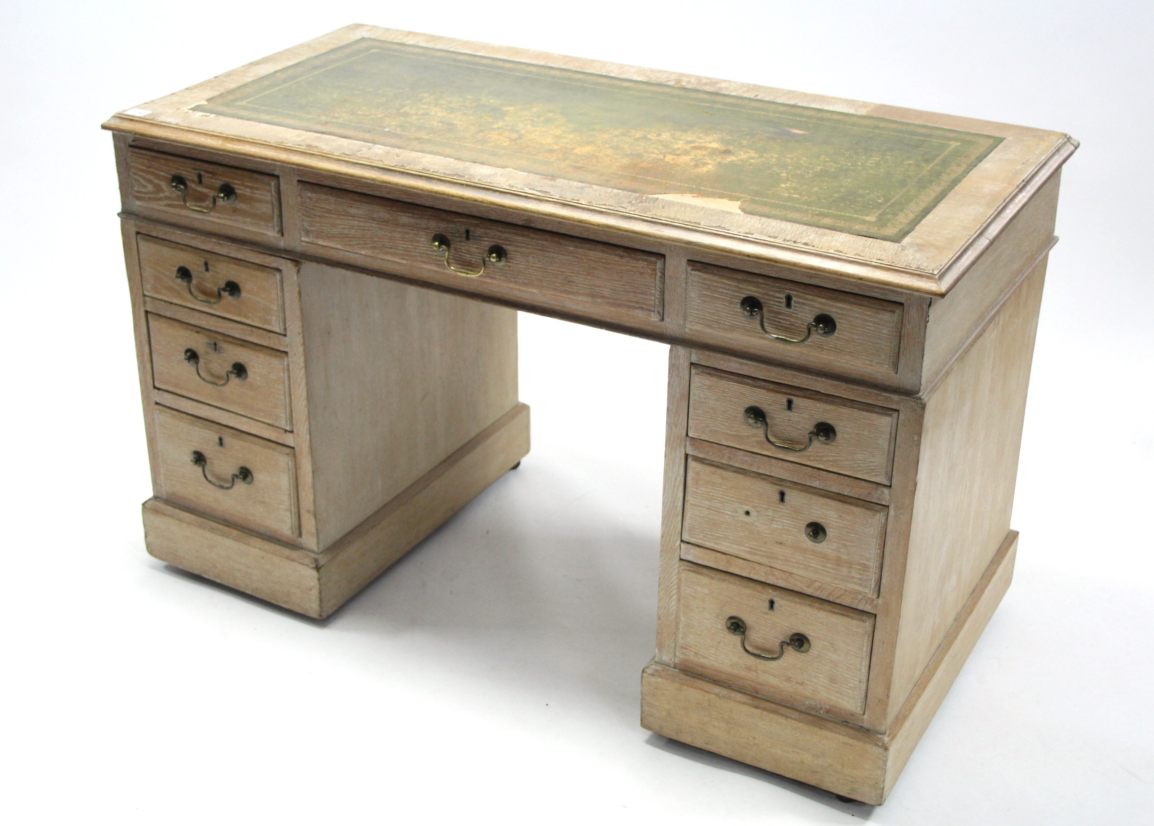 A Victorian limed oak pedestal desk inset gilt-tooled green leather-cloth, fitted with an