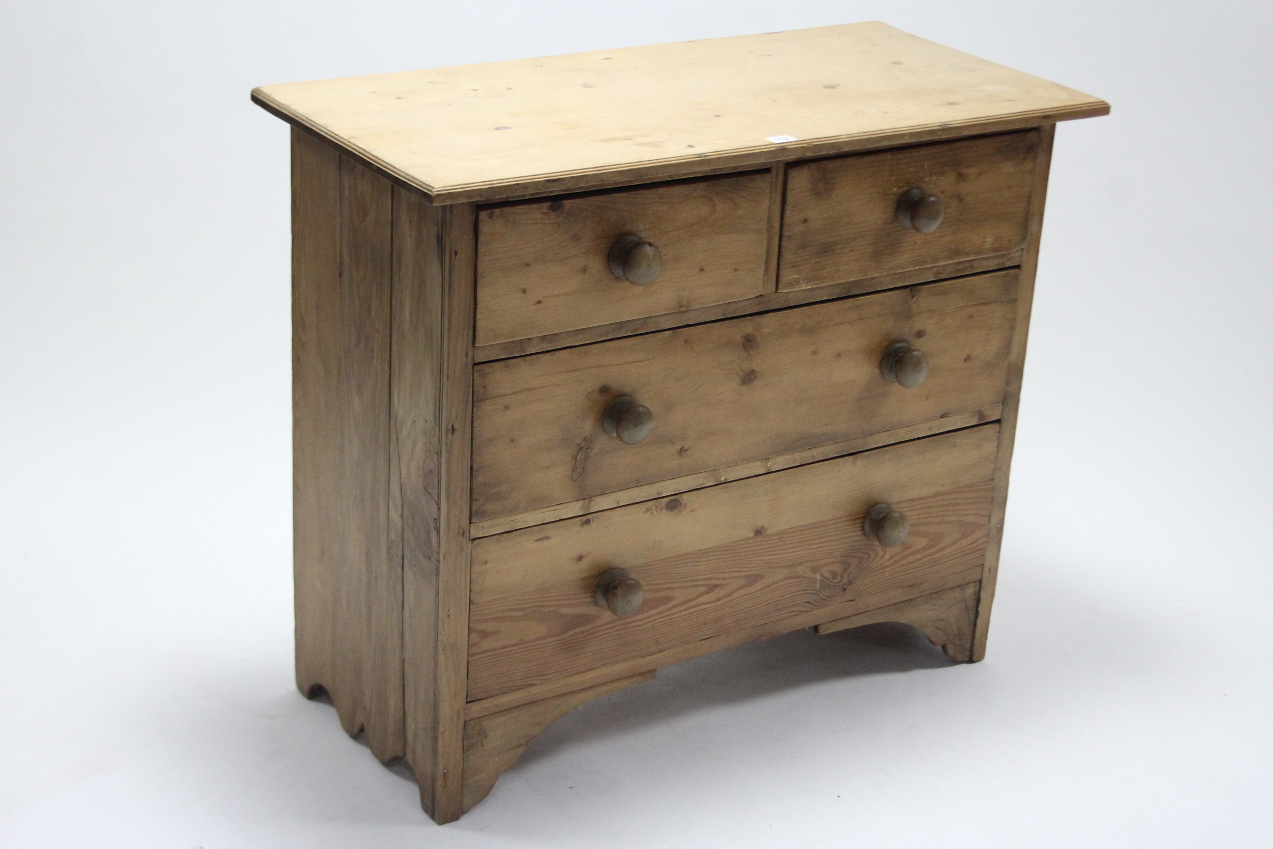 A pine dwarf chest fitted two short and two long graduated drawers with turned knob handles, and