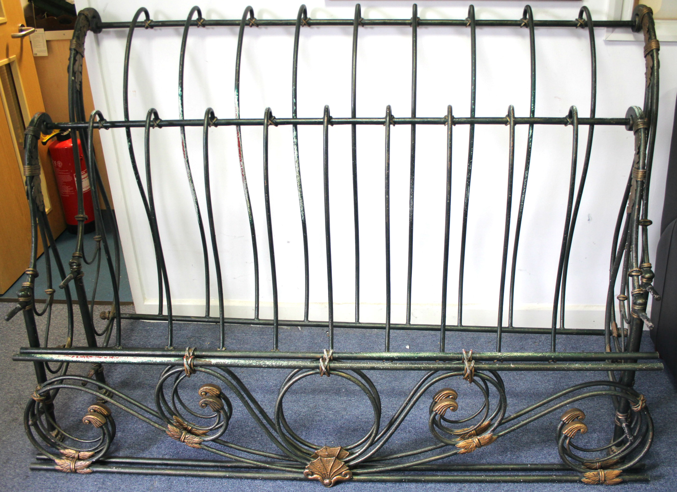 A continental-style green & gold painted wrought-metal 5’ 6” bedstead of scroll design.