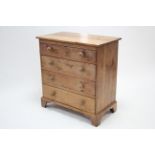 A pine small chest fitted four long graduated drawers with turned knob handles, & on bracket feet,