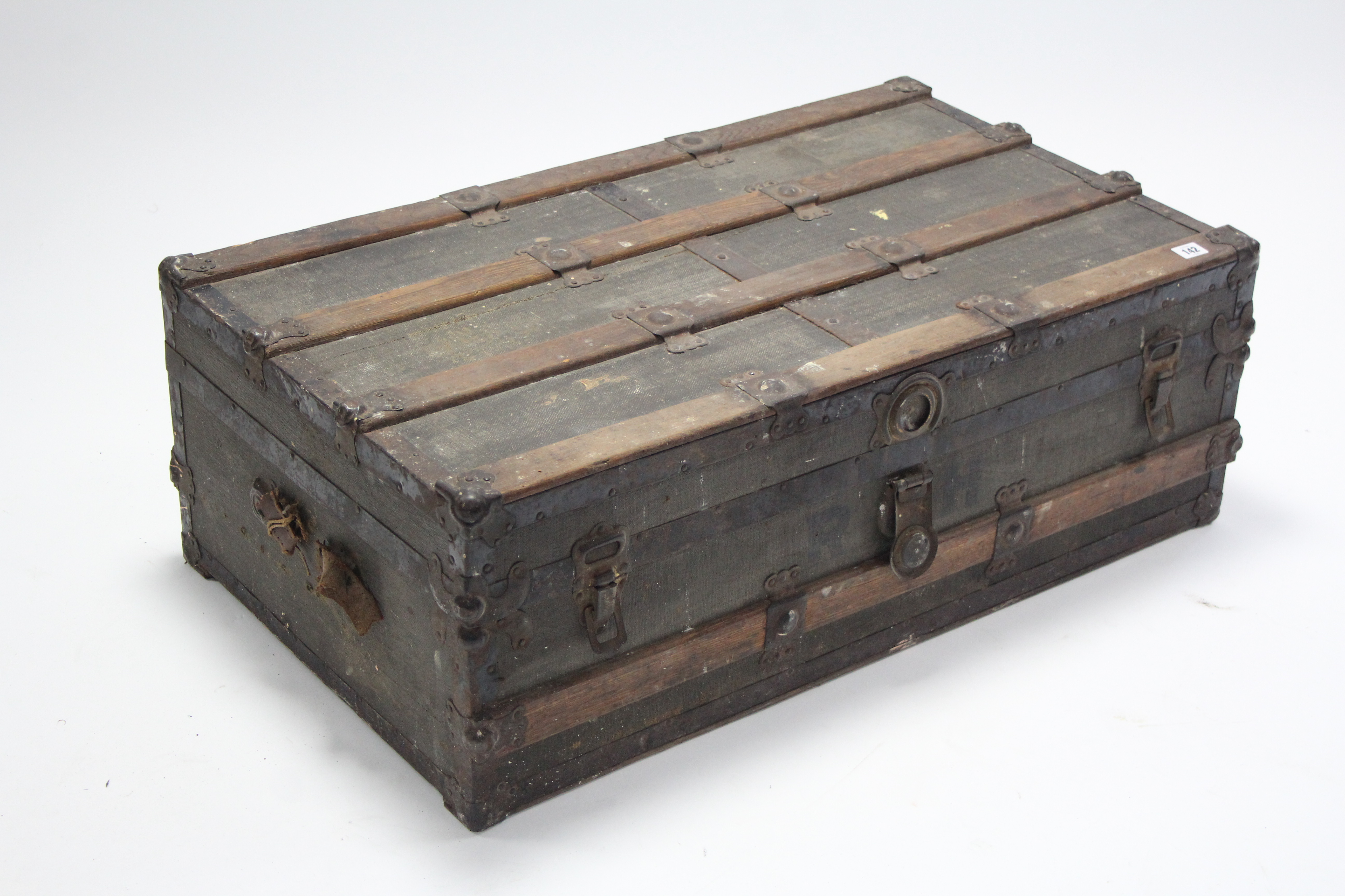 An early 20th century McBrines fibre-covered wooden travelling trunk with fitted interior enclosed