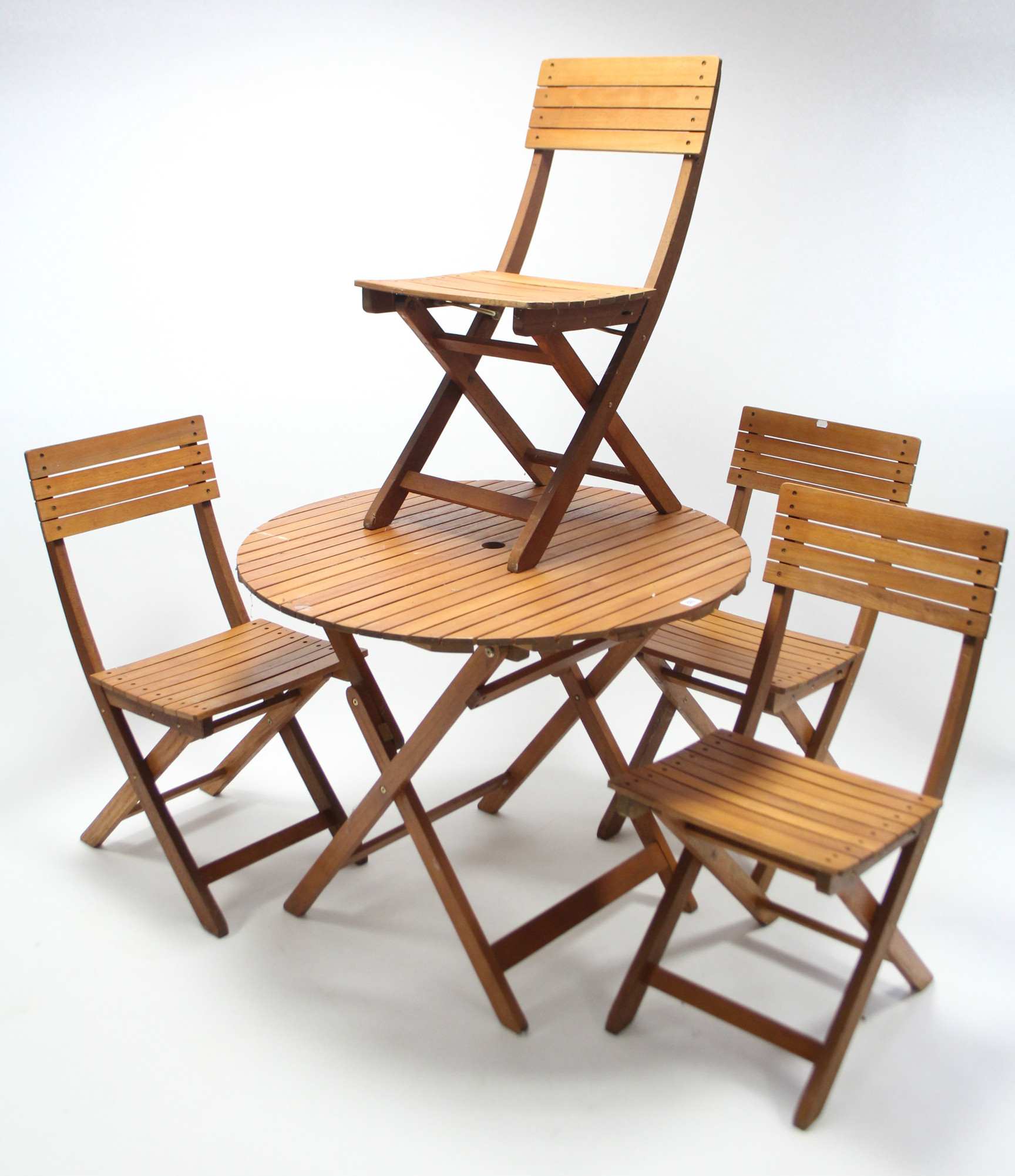 A teak garden table with circular top and on square fold-away legs, 35¼" diam.; and a ditto set of