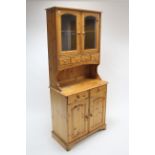 A small pine dresser, the upper part enclosed by pair of glazed doors above four small drawers &