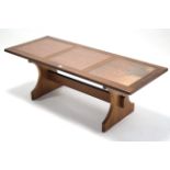 A G-Plan teak low coffee table inset three copper panels to the rectangular top, and on shaped end