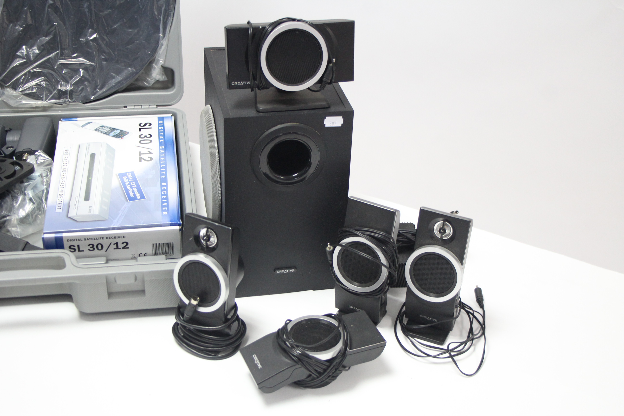 A portable digital satellite receiver, with case; & a set of five creative computer speakers with