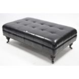 A brass studded black vinyl large rectangular stool with buttoned seat, and on short turned legs