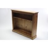 A pine standing open bookcase with two adjustable shelves, & on shaped plinth base, 49¾” wide x 42½”