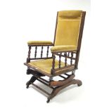 A late 19th/early 20th century beech rocking chair on sprung base, slight faults.