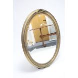 A large gilt frame oval wall mirror with raised border & inset bevelled plate, 42” x 34”.